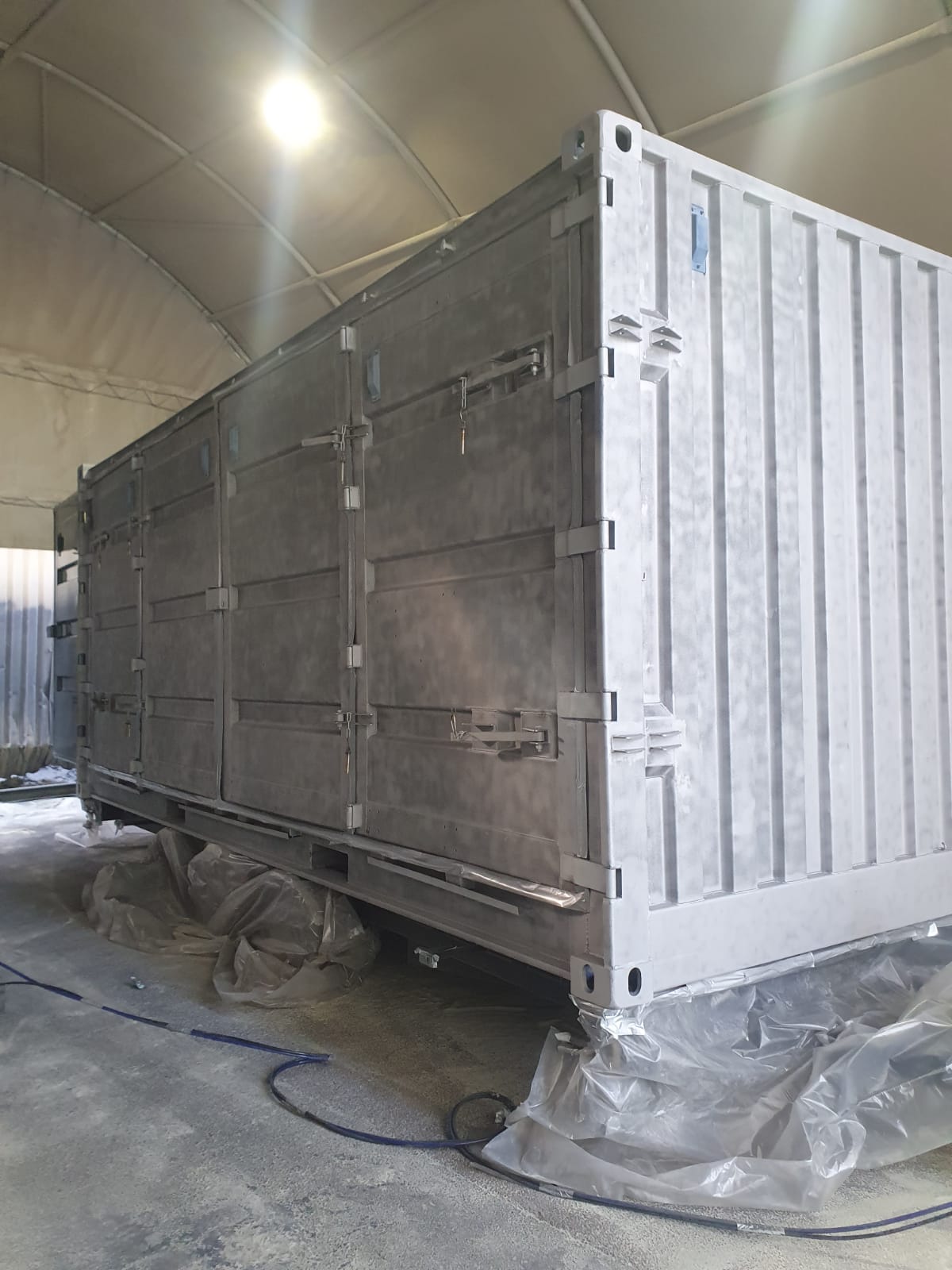 Sandbasting shipping container conversion back to original metal work for clean paint finish
