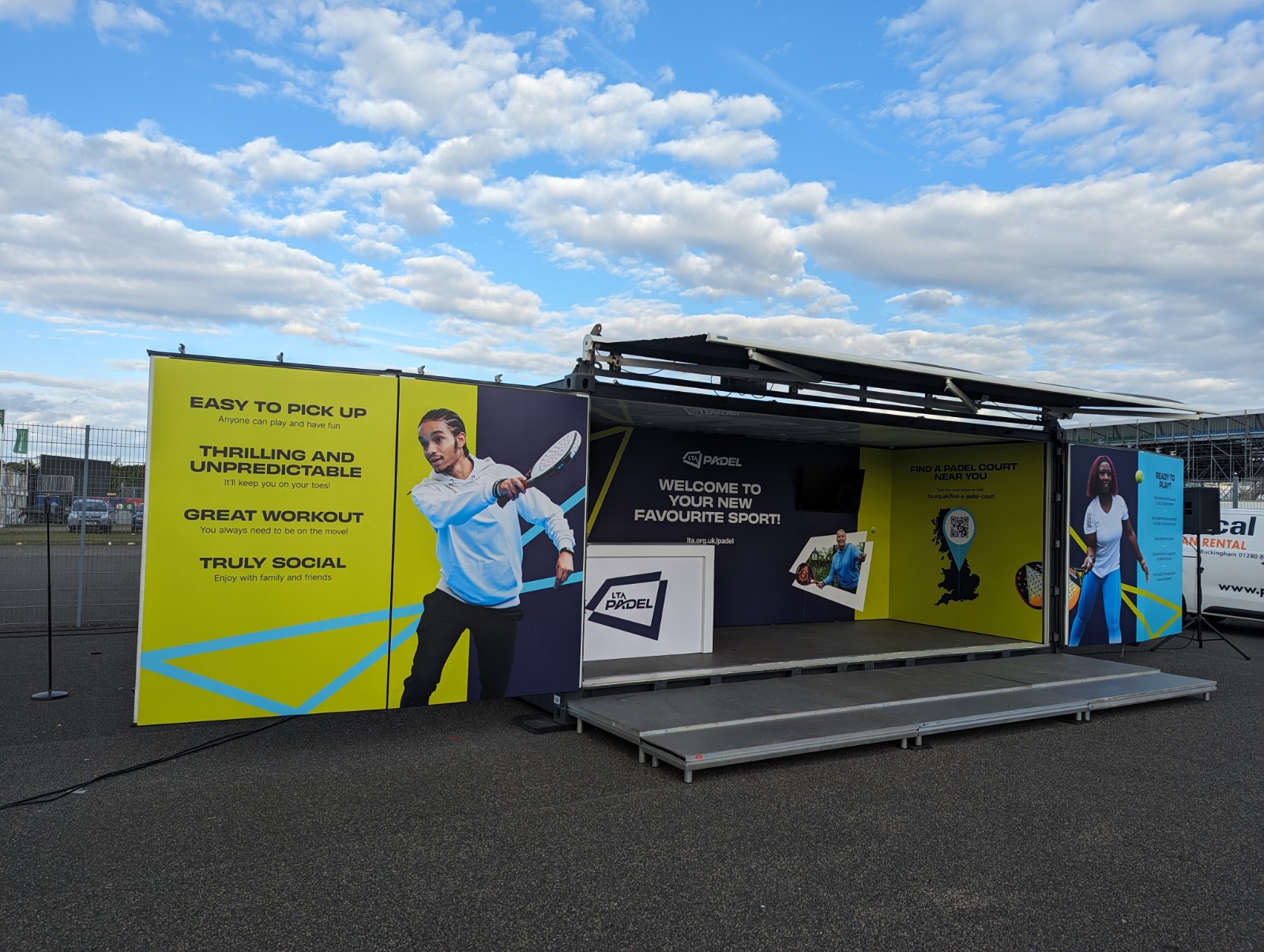 The Lawn Tennis Association LTA at British Grand Prix branded shipping container conversion activation with cargo door using The Event Structure Studio Premium hosting a pop-up padel experience 