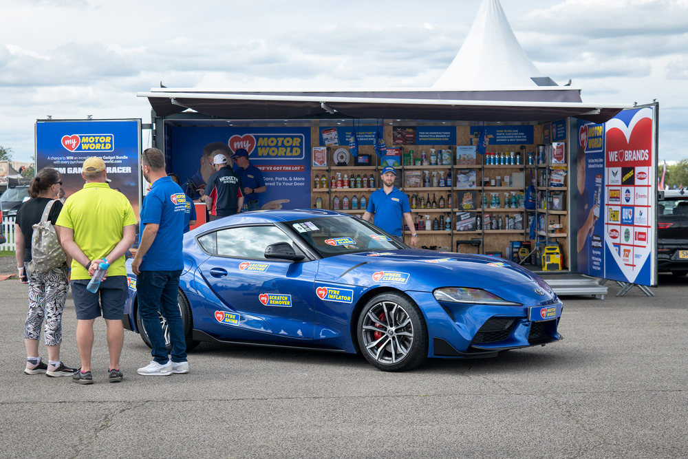 My Motor World branded shipping container conversion activation with cargo doors at Silverstone F1 Festival featuring automotive products to purchase and sports car display