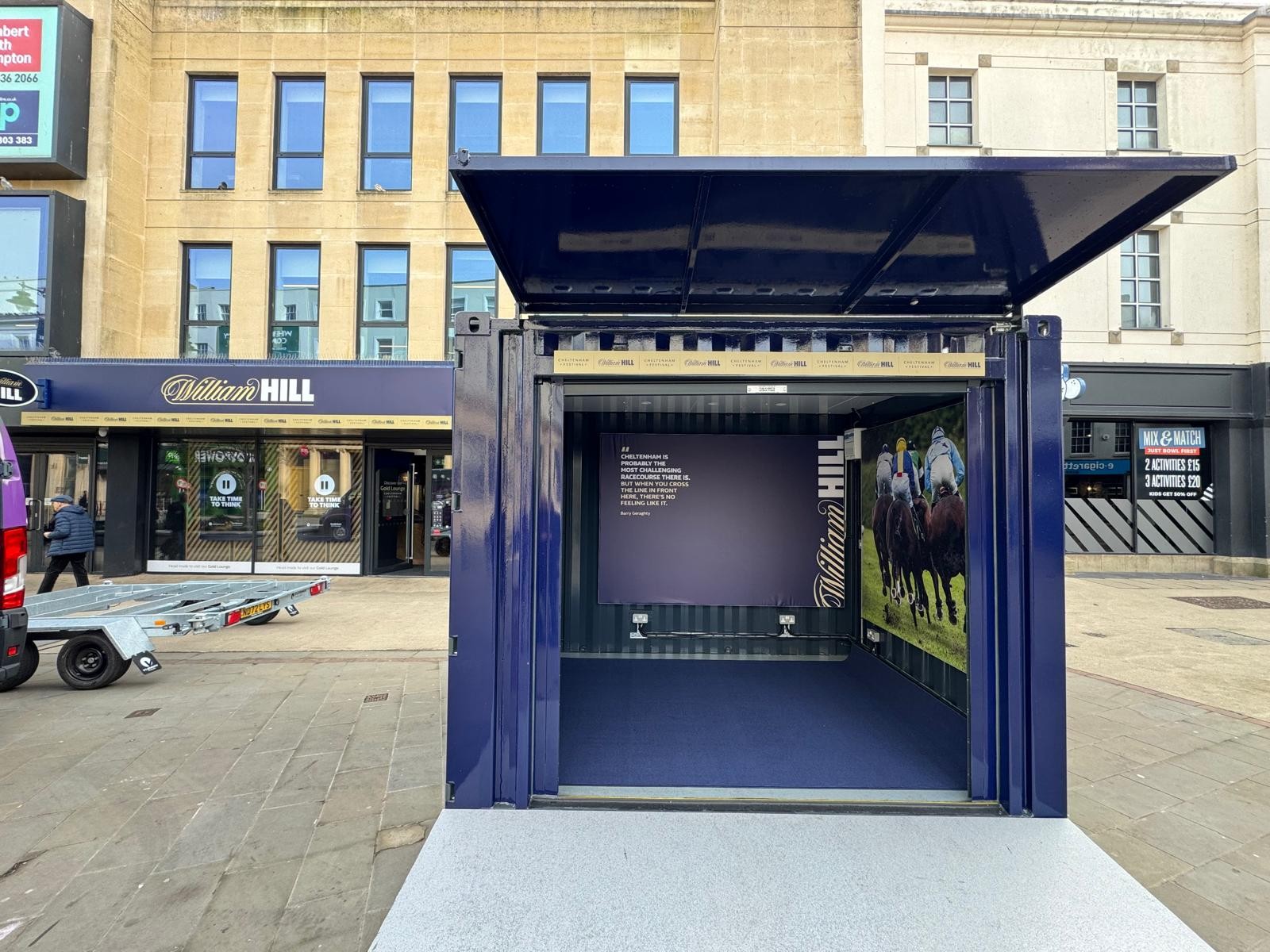 Front view of the William Hill Boutique shipping container at the Cheltenham Festival, showing dual-function roller shutter and branding. 