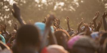 Festival goers enjoying outdoor festival with hands in air