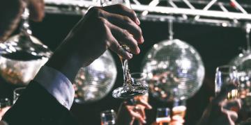 Toasting and raising glasses at a celebratory indoor event 