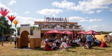 festival bar hire using container bar with rooftop terrace and large crowd 
