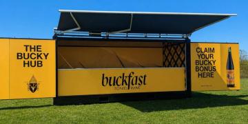 Wide shot of Buckfast container bar activation at a UK festival